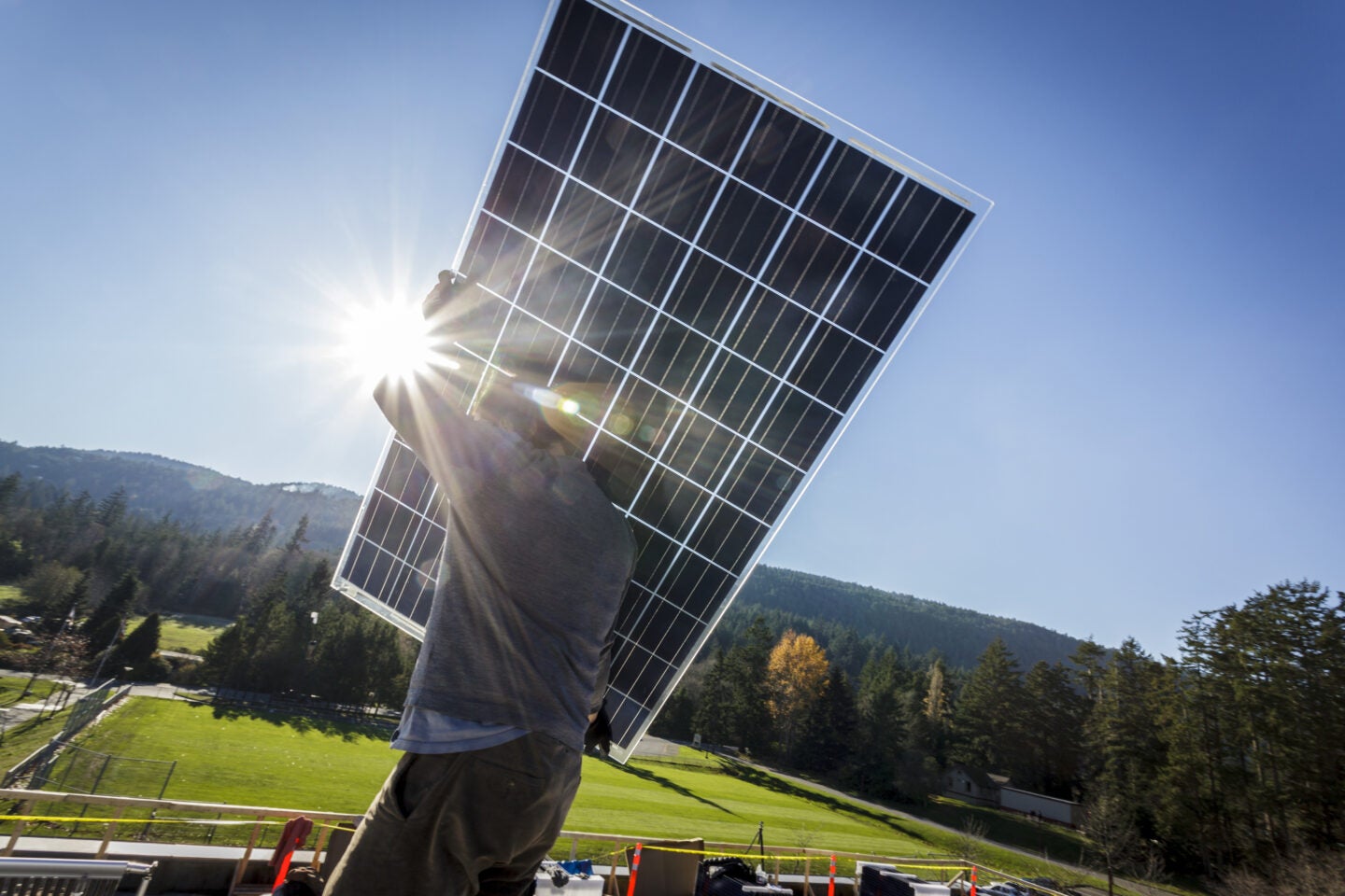 man holding a solar panel.
